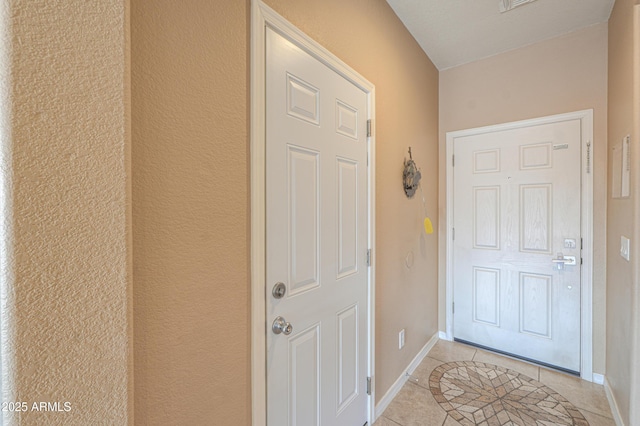 doorway to outside with light tile patterned floors and baseboards