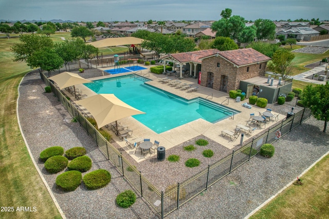 community pool with fence, a patio area, and a residential view