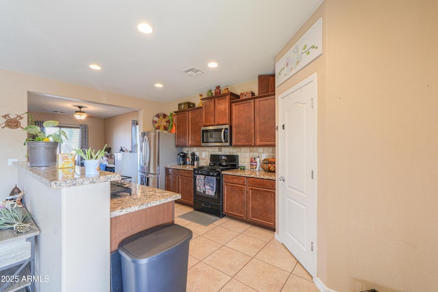 kitchen with backsplash, visible vents, appliances with stainless steel finishes, light tile patterned floors, and light stone counters