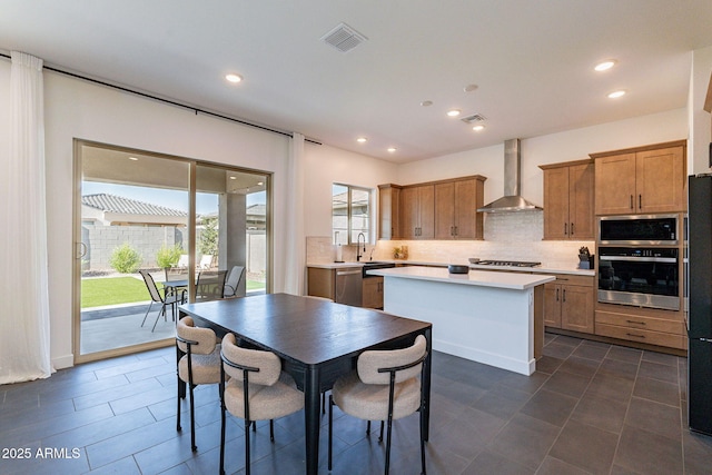 22822 E Watford Dr, Queen Creek, AZ 85142 - kitchen with a center island, wall chimney exhaust hood, appliances with stainless steel finishes, and tasteful backsplash