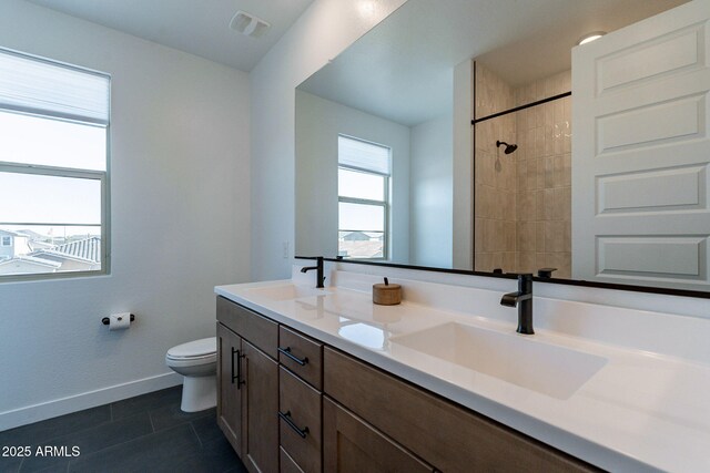 22822 E Watford Dr, Queen Creek, AZ 85142 - bathroom featuring baseboards, toilet, double vanity, and a sink