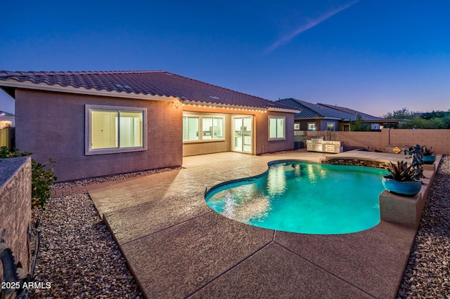 pool at dusk with a patio