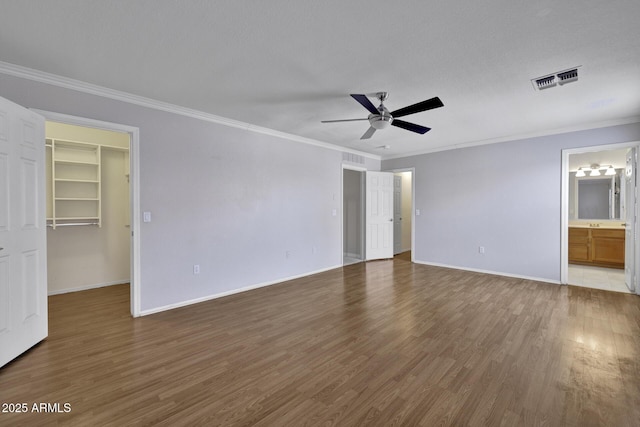 1090 S Bogle Ct, Chandler, AZ 85286 - unfurnished bedroom featuring a spacious closet, ornamental molding, wood finished floors, connected bathroom, and a ceiling fan