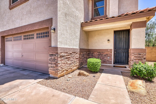 1090 S Bogle Ct, Chandler, AZ 85286 - view of exterior entry with stucco siding, a garage, stone siding, and concrete driveway