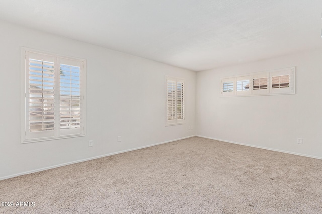 carpeted empty room featuring plenty of natural light