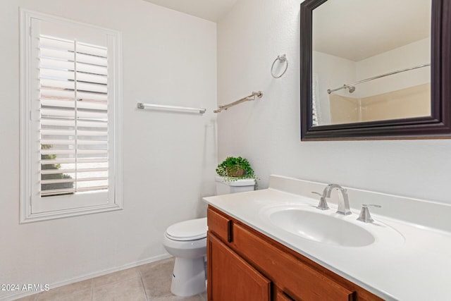 bathroom with tile patterned flooring, vanity, toilet, and walk in shower