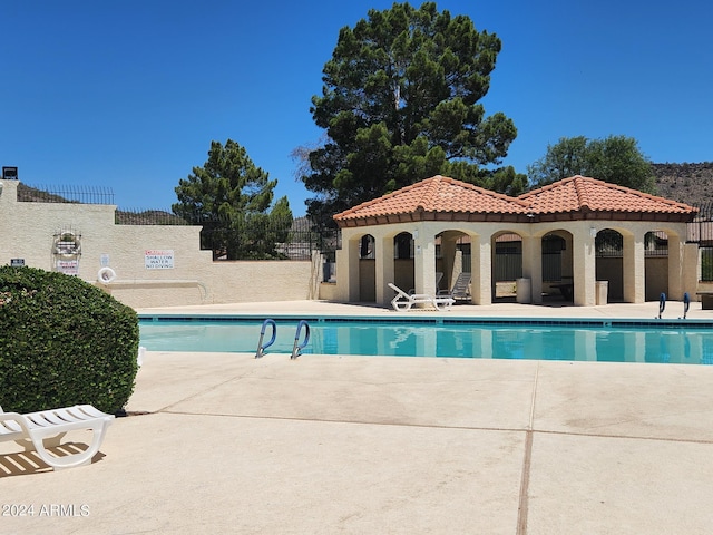 view of pool with an outbuilding and a patio