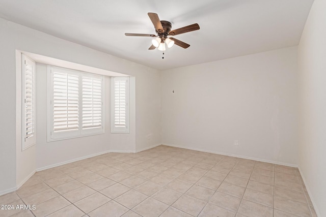 spare room with ceiling fan and light tile patterned floors