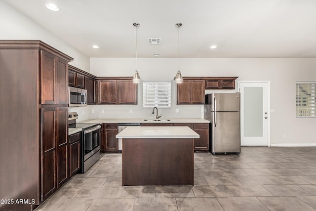 2000 N 36th St Unit 17, Phoenix, AZ 85008 - kitchen with stainless steel appliances, light countertops, a center island, dark brown cabinetry, and pendant lighting