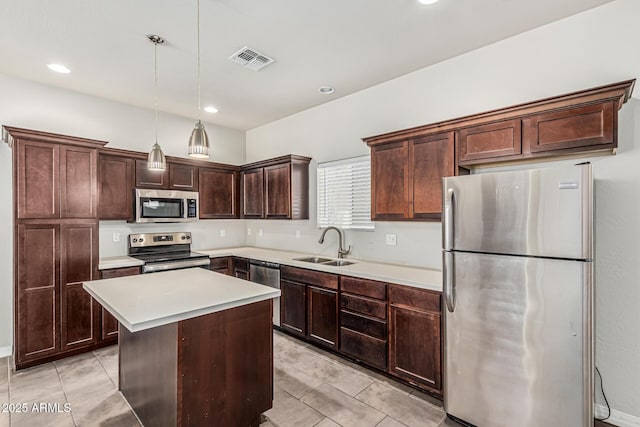 2000 N 36th St Unit 17, Phoenix, AZ 85008 - kitchen with appliances with stainless steel finishes, light countertops, dark brown cabinetry, a kitchen island, and pendant lighting