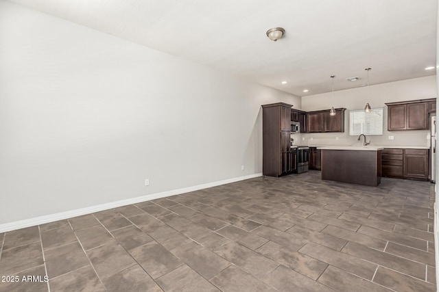 2000 N 36th St Unit 17, Phoenix, AZ 85008 - kitchen with light countertops, open floor plan, dark brown cabinets, recessed lighting, and decorative light fixtures