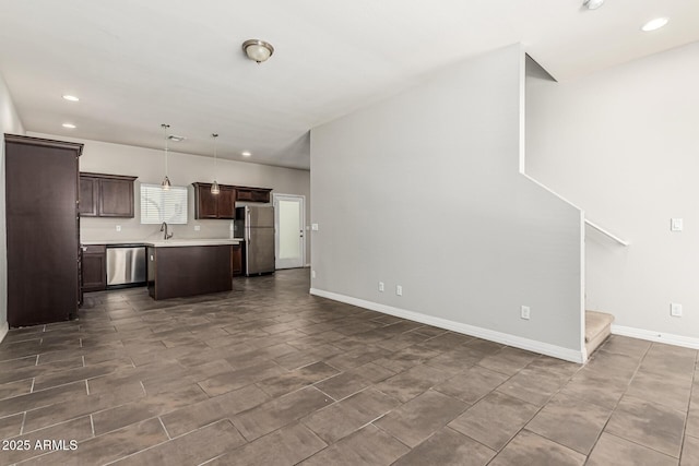 2000 N 36th St Unit 17, Phoenix, AZ 85008 - kitchen featuring stainless steel appliances, open floor plan, dark brown cabinetry, light countertops, and a kitchen island