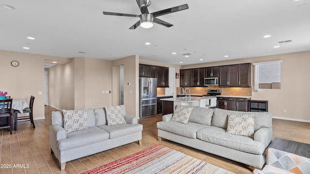 living area featuring recessed lighting, visible vents, ceiling fan, and light wood finished floors