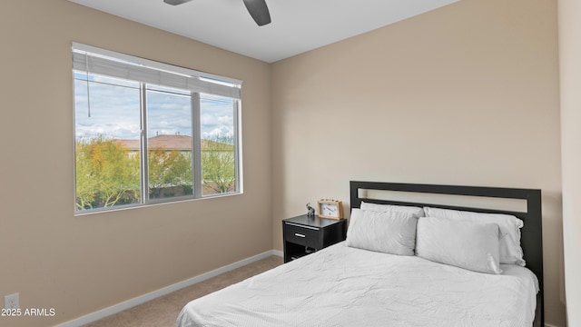 carpeted bedroom with a ceiling fan and baseboards