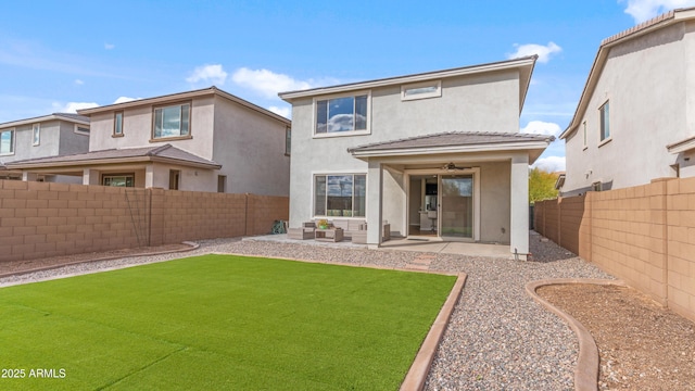 rear view of house featuring a fenced backyard, ceiling fan, stucco siding, a patio area, and a lawn