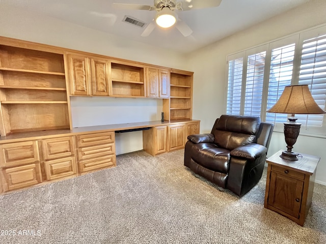 interior space featuring built in desk and ceiling fan