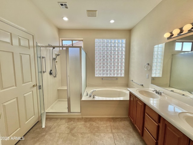 bathroom featuring a healthy amount of sunlight, independent shower and bath, tile patterned flooring, and vanity