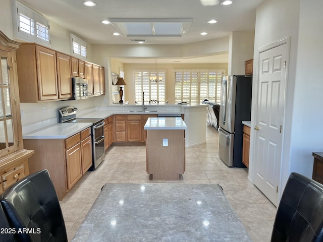 kitchen with a kitchen island, appliances with stainless steel finishes, hanging light fixtures, kitchen peninsula, and a healthy amount of sunlight