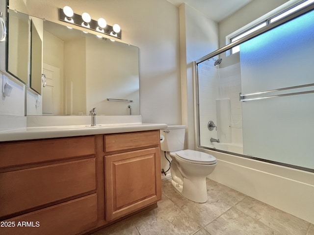 full bathroom with enclosed tub / shower combo, vanity, and toilet