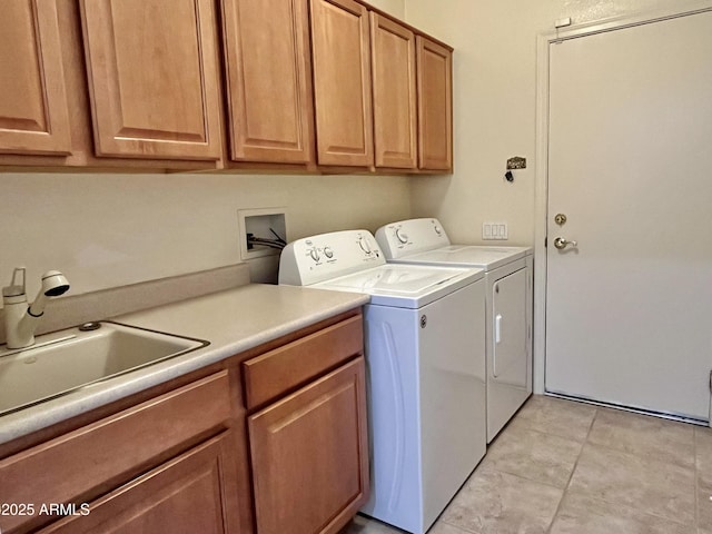 clothes washing area featuring sink, light tile patterned floors, cabinets, and independent washer and dryer