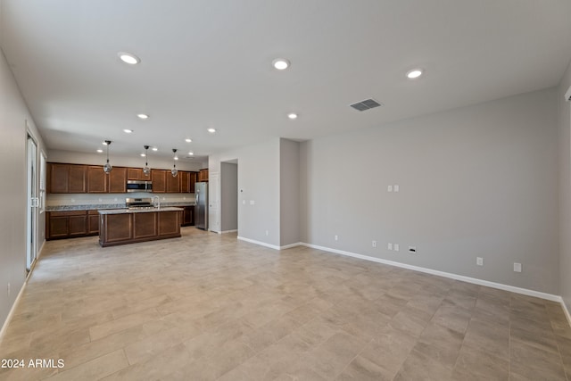 kitchen featuring pendant lighting, a kitchen island, and appliances with stainless steel finishes