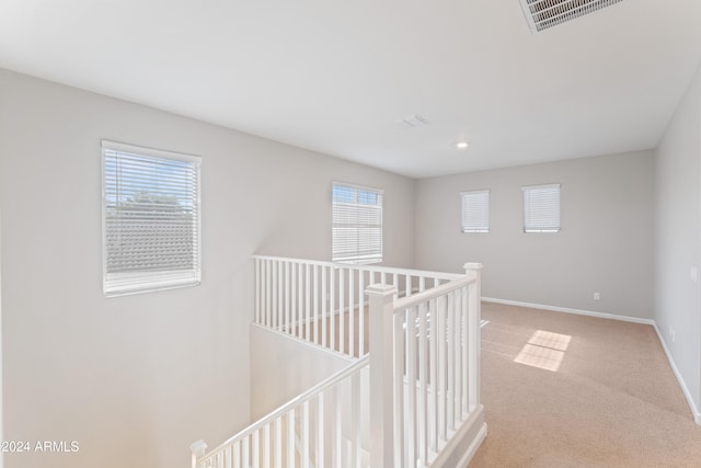 hallway with light carpet and a wealth of natural light