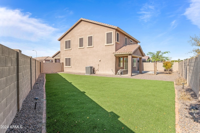 back of property featuring central AC, a patio area, and a lawn