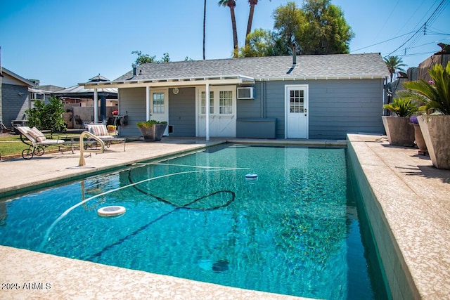 view of swimming pool with a patio area and a wall unit AC