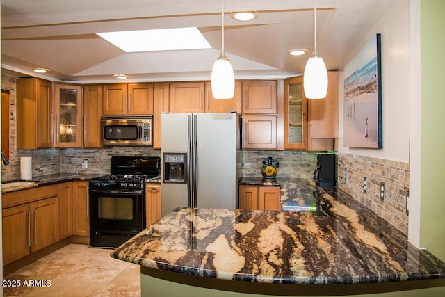 kitchen with decorative light fixtures, decorative backsplash, dark stone countertops, and appliances with stainless steel finishes