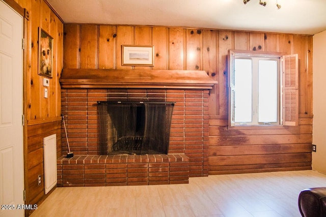 unfurnished living room featuring a fireplace and wood walls