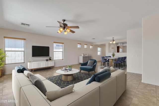 living area with visible vents, ceiling fan, and light tile patterned flooring
