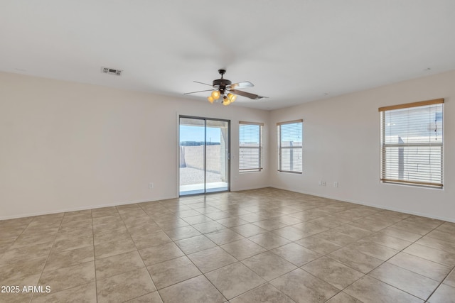 spare room featuring light tile patterned floors, baseboards, a ceiling fan, and visible vents