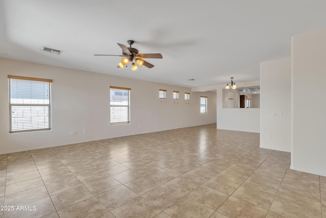 spare room with ceiling fan, visible vents, and light tile patterned floors