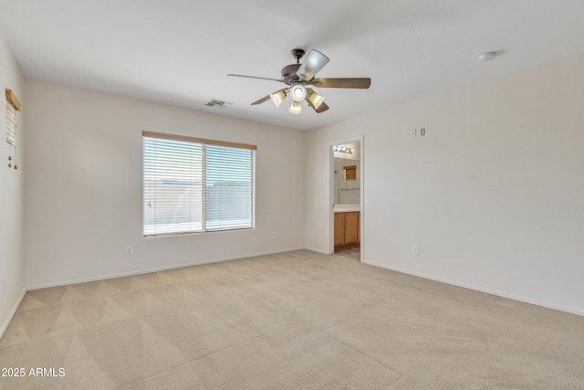 spare room with baseboards, visible vents, light colored carpet, and a ceiling fan