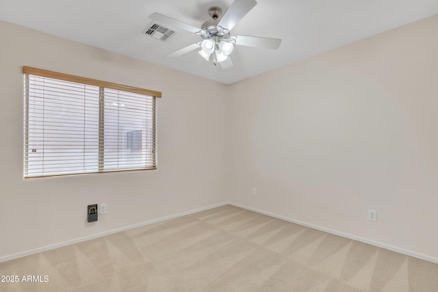 unfurnished room with visible vents, baseboards, a ceiling fan, and light colored carpet