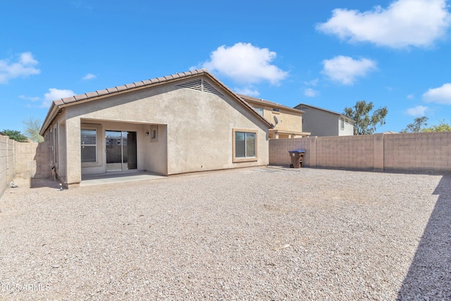 rear view of house featuring a patio, a fenced backyard, and stucco siding
