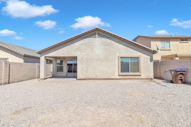back of property with a patio area, stucco siding, and fence