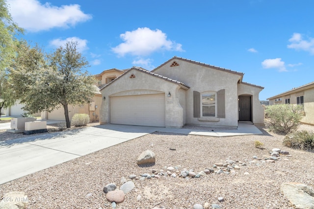 mediterranean / spanish house with an attached garage, driveway, stucco siding, and a tile roof