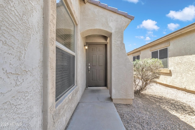 view of exterior entry featuring stucco siding