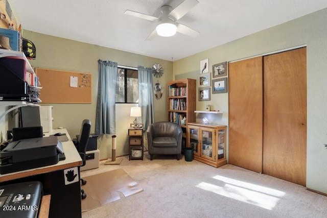 carpeted home office featuring ceiling fan