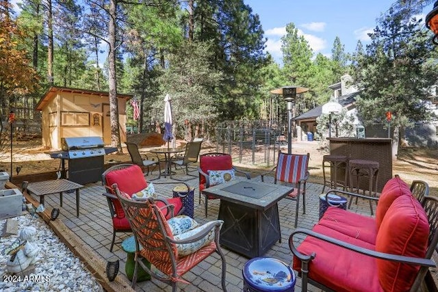 view of patio / terrace with area for grilling, an outdoor living space with a fire pit, and a shed