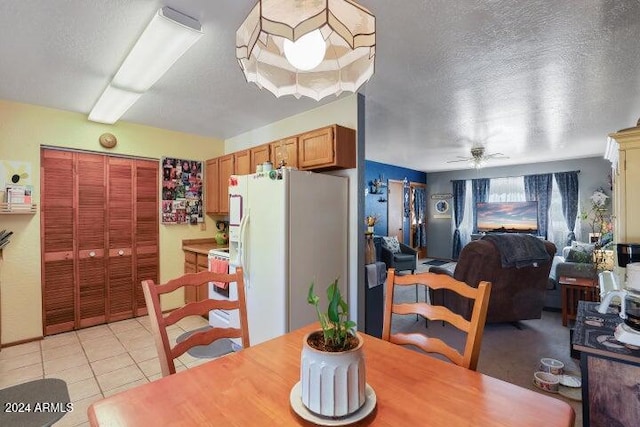 dining area with ceiling fan, light tile patterned flooring, and a textured ceiling
