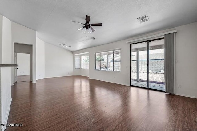 empty room featuring ceiling fan, a textured ceiling, dark hardwood / wood-style flooring, and lofted ceiling