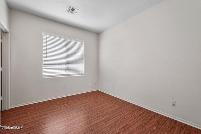 empty room with dark wood-type flooring