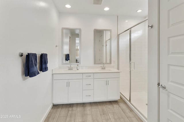 bathroom featuring a sink, double vanity, and a shower stall
