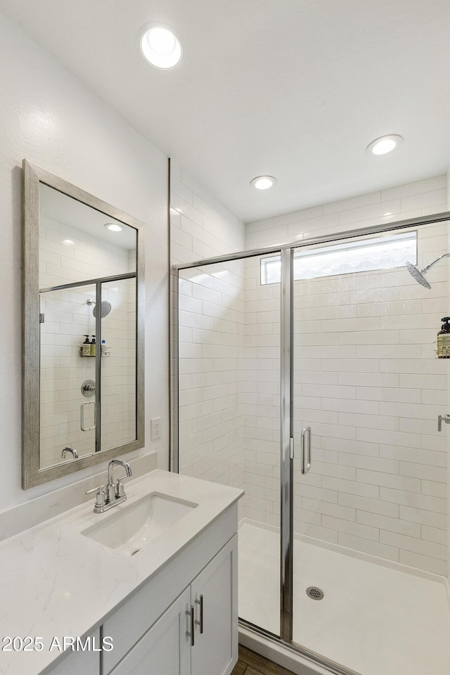 full bathroom with a stall shower, vanity, and recessed lighting