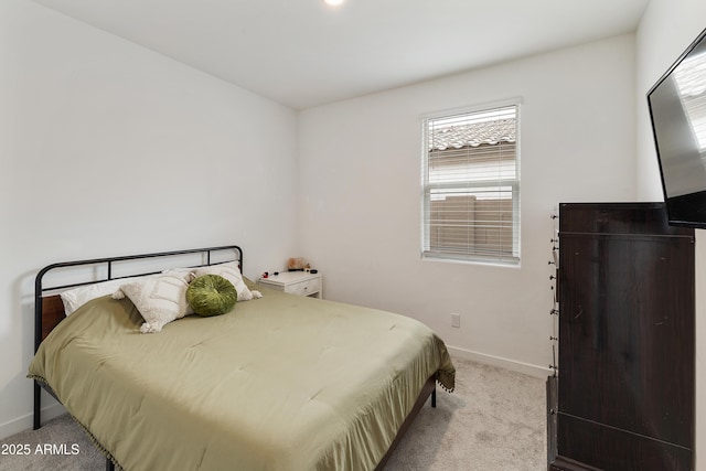 bedroom featuring baseboards, multiple windows, and light colored carpet