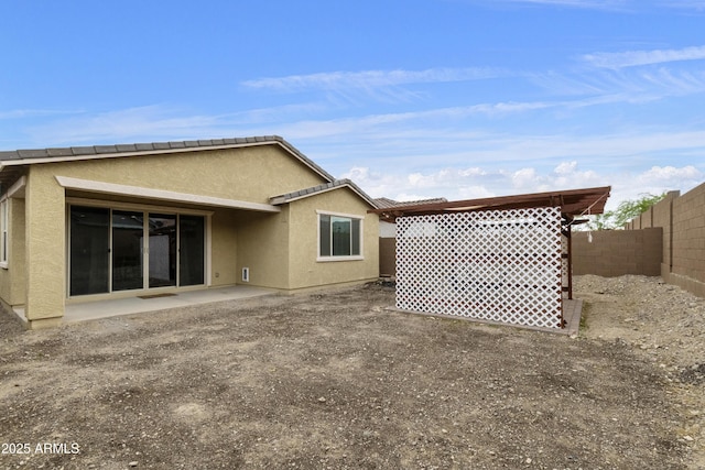 back of property with a patio area, stucco siding, and a fenced backyard