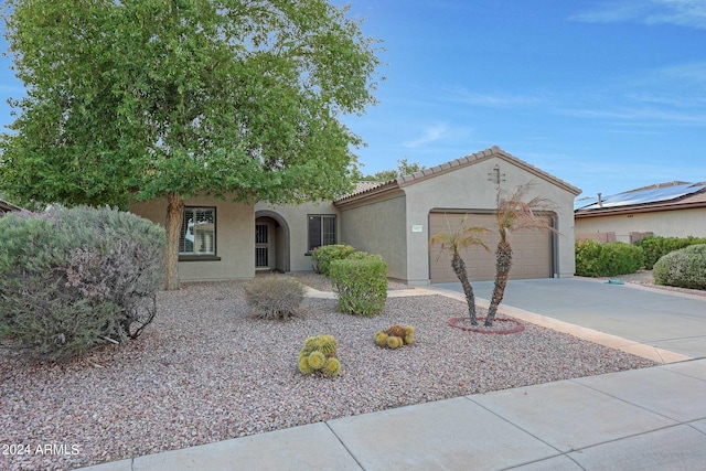 view of front of property with a garage, a tiled roof, concrete driveway, and stucco siding