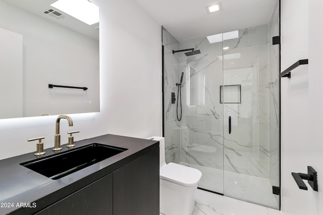 bathroom featuring toilet, vanity, and a shower with shower door